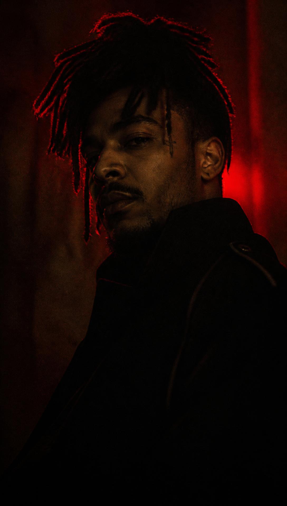 Portrait de Don Eli dans une lumière rouge tamisée